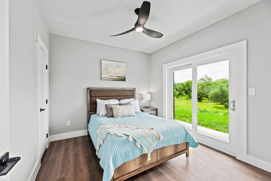 Bedroom featuring wood-finish flooring, a contemporary ceiling fan, and a large sliding glass door