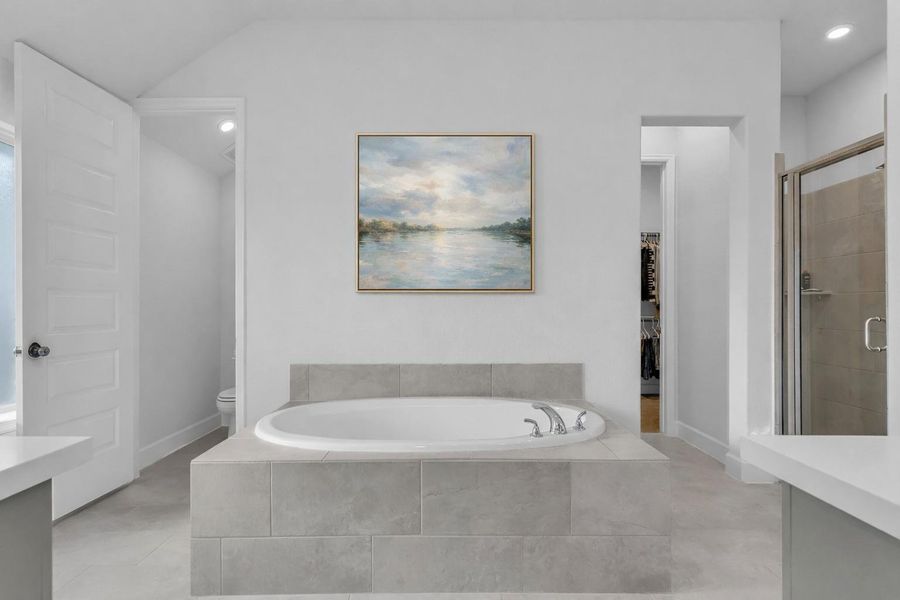 Relax in your primary bath with double vanity sinks, soaker tub, and standing showing.