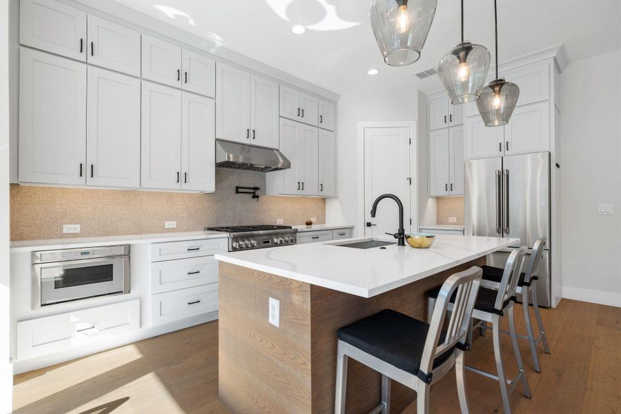 Kitchen featuring decorative backsplash, dark wood-type flooring, appliances with stainless steel finishes, and recessed lighting