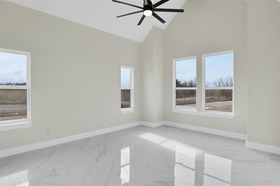 Spare room featuring ceiling fan and high vaulted ceiling