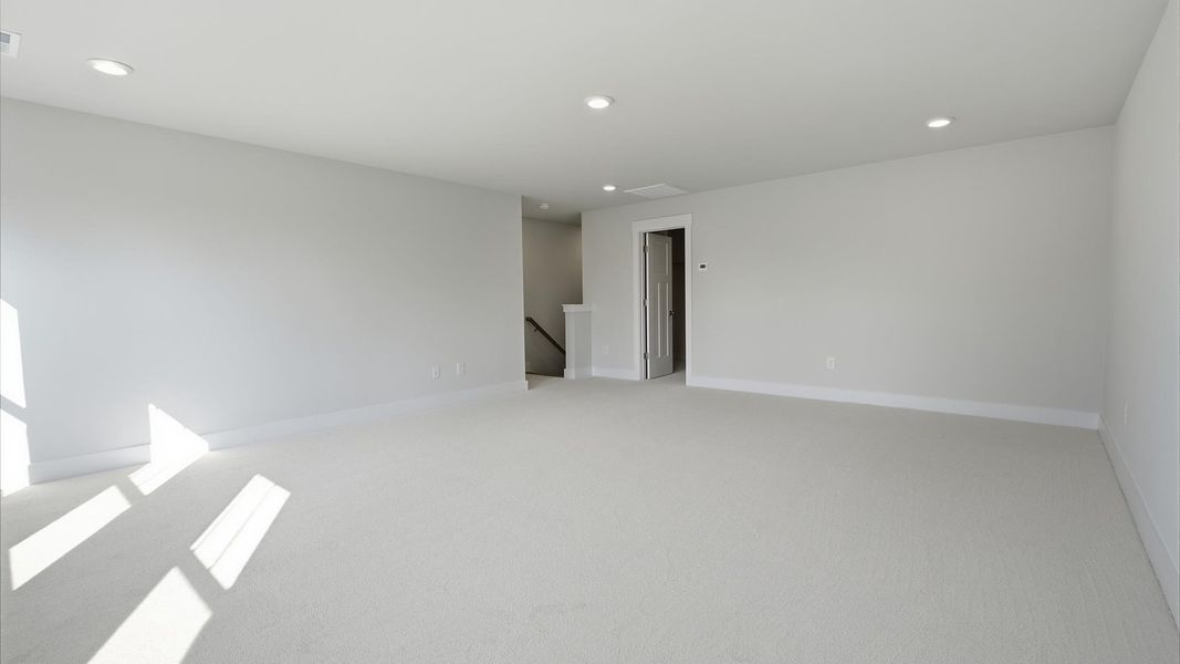 Refined bonus room with comfortable carpeted flooring and tasteful design throughout by DRB Homes