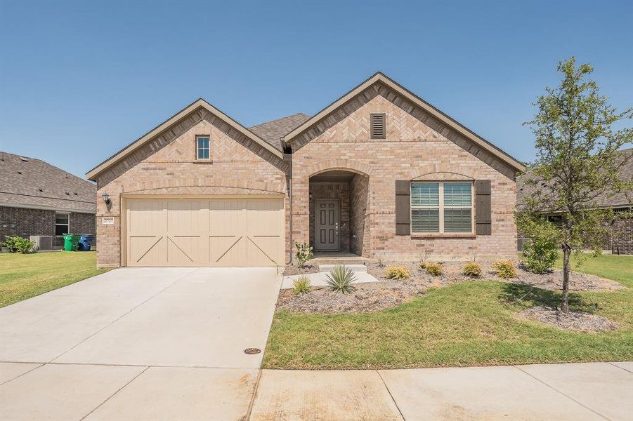 View of front of home with brick siding, driveway, a front yard, and an attached garage View of front of home with brick siding, driveway, a front yard, and an attached garage