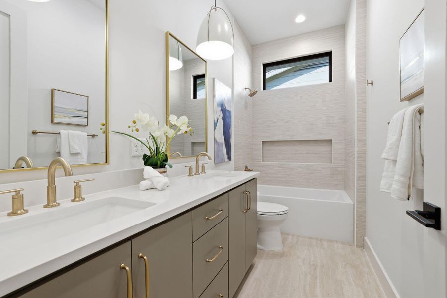 Bathroom with double vanity and shower / washtub combination