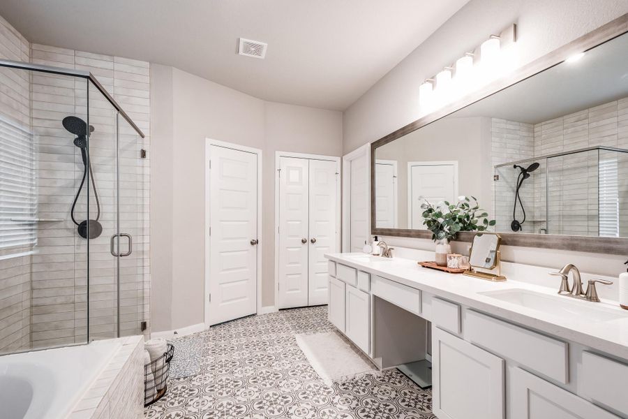 This bathroom features a spacious, elegant design with a large glass-enclosed shower, a dual-sink vanity, and stylish patterned floor tiles. The neutral color palette and ample lighting create a bright and inviting atmosphere. This bathroom features a spacious, elegant design with a large glass-enclosed shower, a dual-sink vanity, and stylish patterned floor tiles. The neutral color palette and ample lighting create a bright and inviting atmosphere.