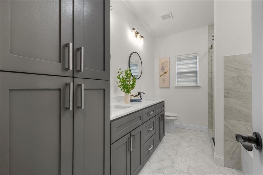 Bathroom with vanity, an enclosed shower, tile patterned floors, and toilet