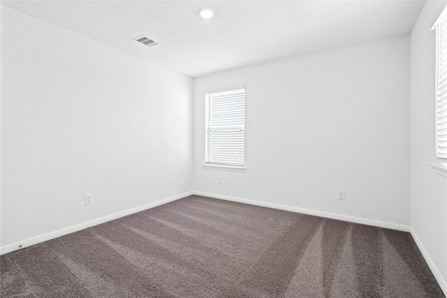 This secondary bedroom offers comfort and style with plush carpeting, neutral paint tones, recessed lighting, a large window with blinds, and a generously sized closet. This secondary bedroom offers comfort and style with plush carpeting, neutral paint tones, recessed lighting, a large window with blinds, and a generously sized closet.