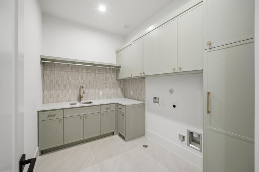 Spacious laundry room with utility sink and ample storage.