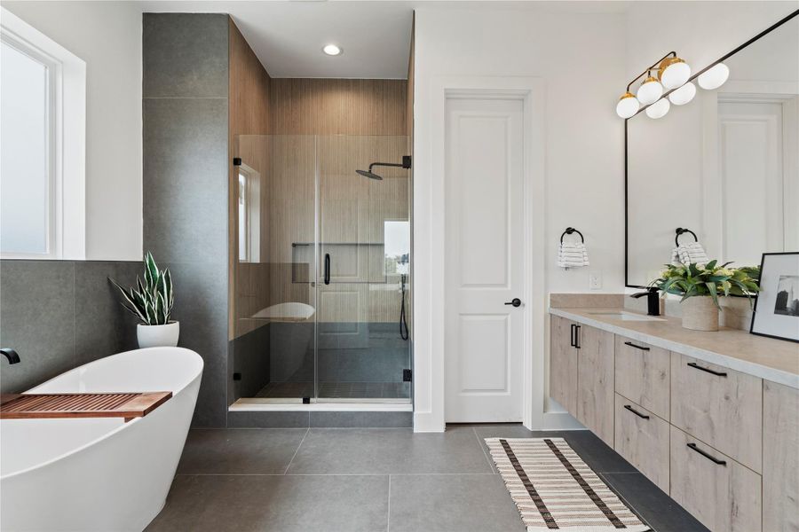 Step into your spacious ensuite bath featuring floating dual vanities with generous storage, a deep soaking tub, and a frameless glass shower accented with modern fluted tile. Step into your spacious ensuite bath featuring floating dual vanities with generous storage, a deep soaking tub, and a frameless glass shower accented with modern fluted tile.