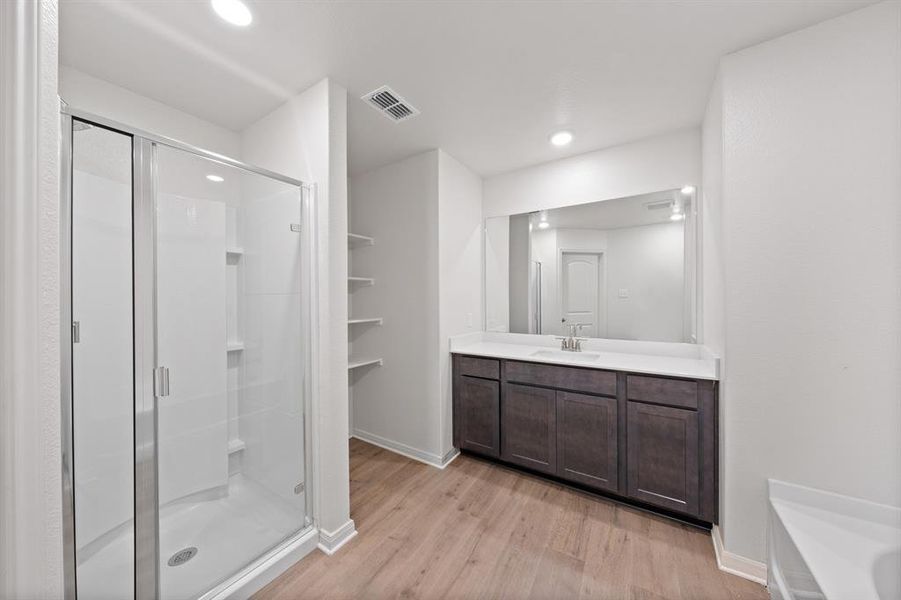 Bathroom with a shower with door, wood-style flooring, and vanity