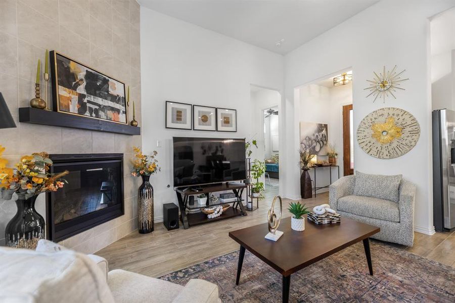 Living room featuring a fireplace, wood finished floors, and a ceiling fan Living room featuring a fireplace, wood finished floors, and a ceiling fan