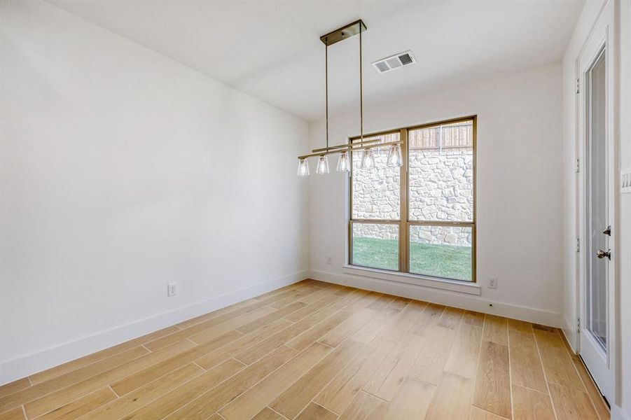 Unfurnished dining area with baseboards and light wood-style floors