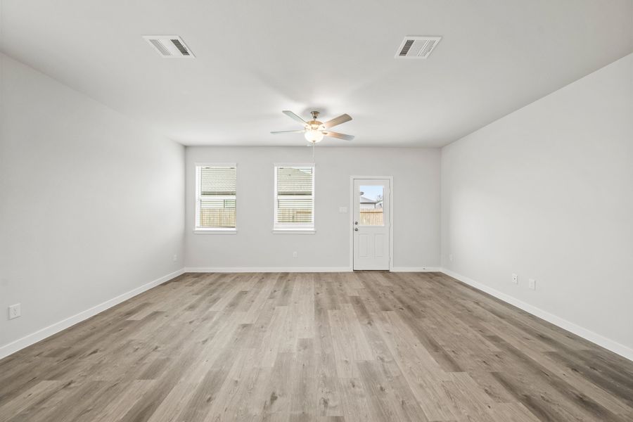 A room with a wood floor and a ceiling fan.
