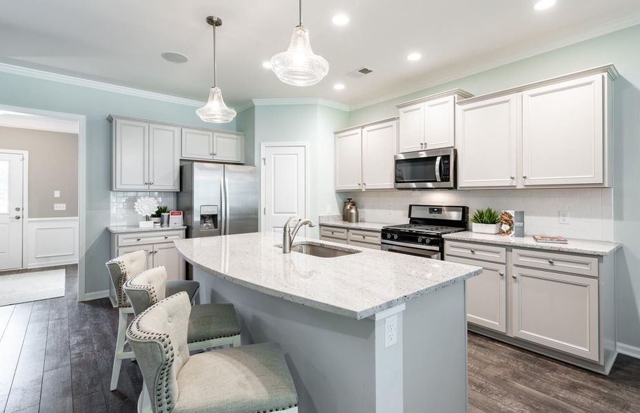 A granite kitchen island and white countertops.