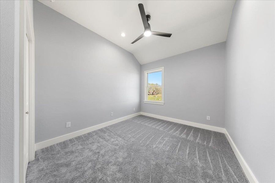 Carpeted spare room with lofted ceiling, ceiling fan, and recessed lighting Carpeted spare room with lofted ceiling, ceiling fan, and recessed lighting