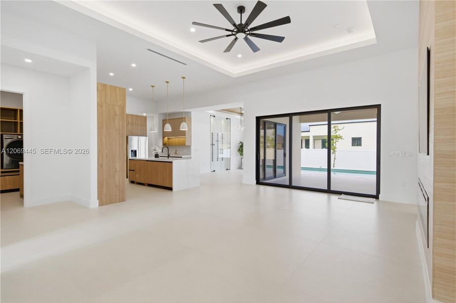 Oversized sliding glass doors provide abundant natural light and seamless access to the pool area. Oversized sliding glass doors provide abundant natural light and seamless access to the pool area.