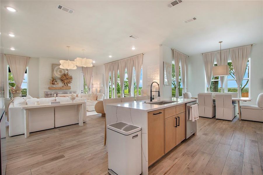 Kitchen with open floor plan, healthy amount of natural light, light brown cabinets, and recessed lighting Kitchen with open floor plan, healthy amount of natural light, light brown cabinets, and recessed lighting