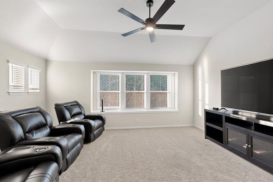 Living room with vaulted ceiling, healthy amount of natural light, and light colored carpet Living room with vaulted ceiling, healthy amount of natural light, and light colored carpet