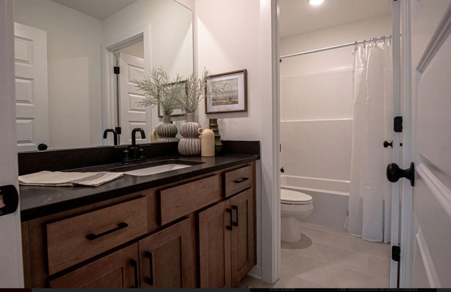 Bathroom featuring vanity, shower / bath combination with curtain, and light tile patterned floors