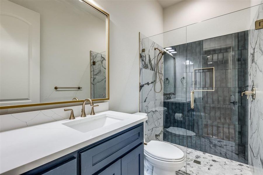 Bathroom featuring vanity, toilet, and an enclosed shower