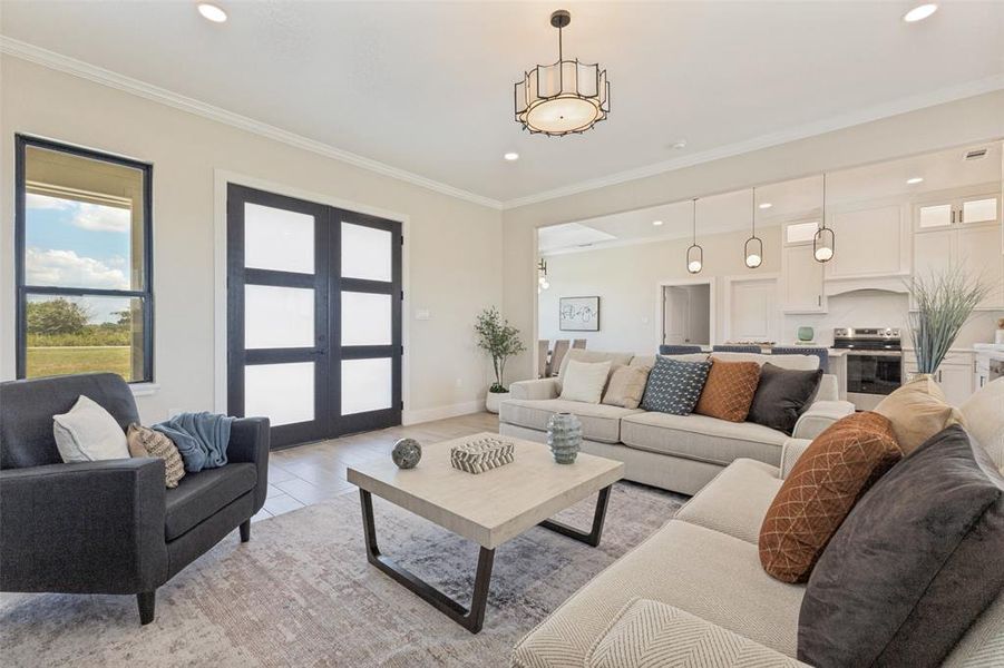 Spacious open-concept living area featuring a modern chandelier, recessed lighting, and crown molding