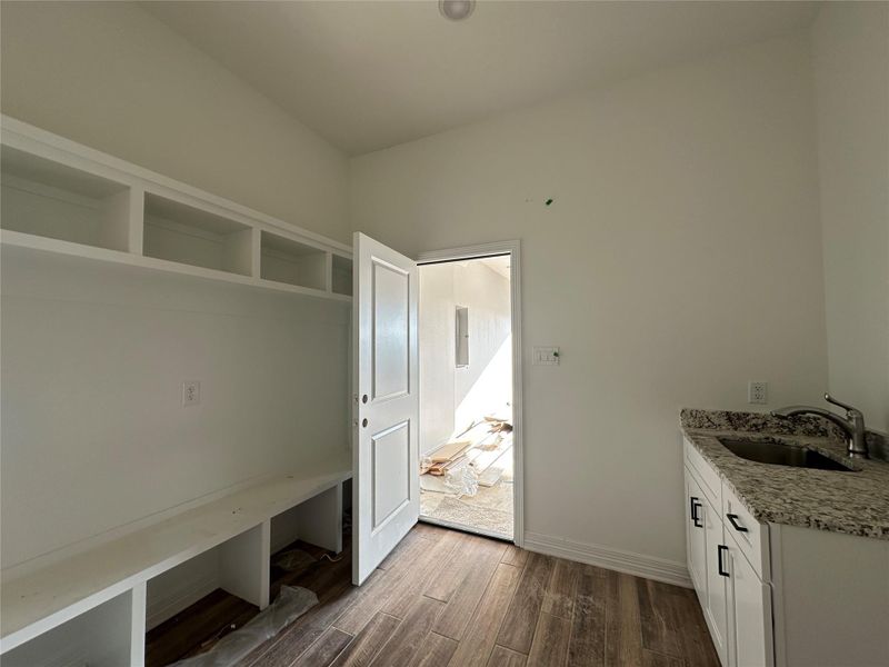Mudroom with dark wood-type flooring and a sink