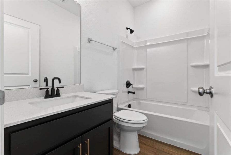 Full bathroom featuring dark wood-style flooring, vanity, and shower / bathtub combination