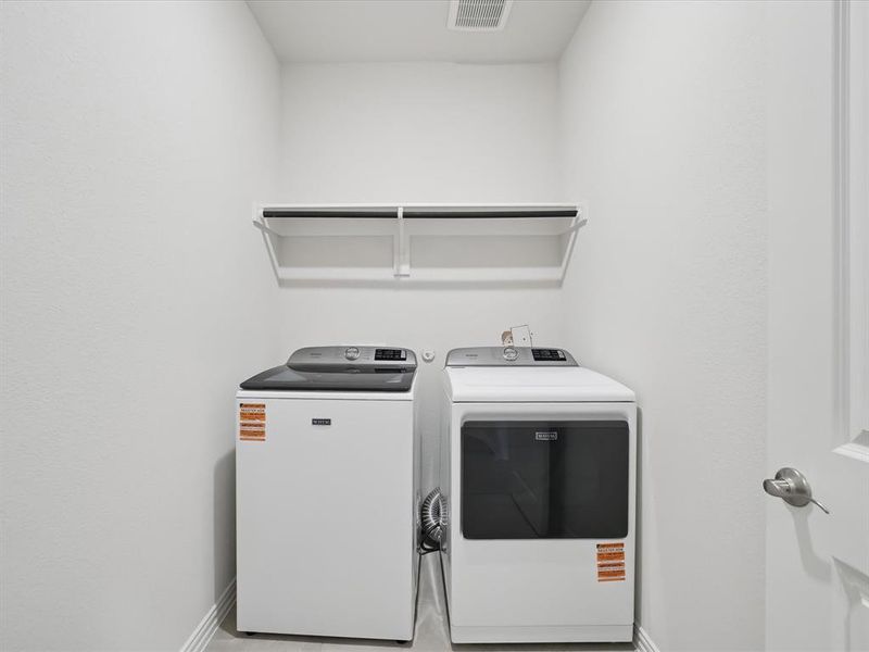 Laundry room featuring washing machine and dryer and baseboards