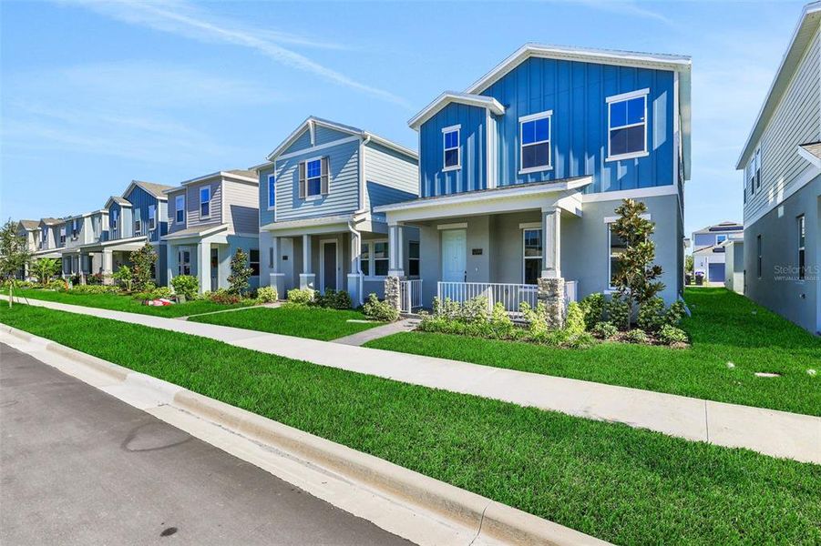 Front exterior of a new home in Serenade at Ovation, Winter Garden, FL, highlighting curb appeal (Image 2). Front exterior of a new home in Serenade at Ovation, Winter Garden, FL, highlighting curb appeal (Image 2).