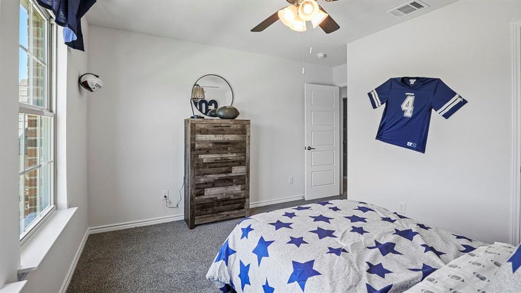 Bedroom featuring dark carpet and ceiling fan