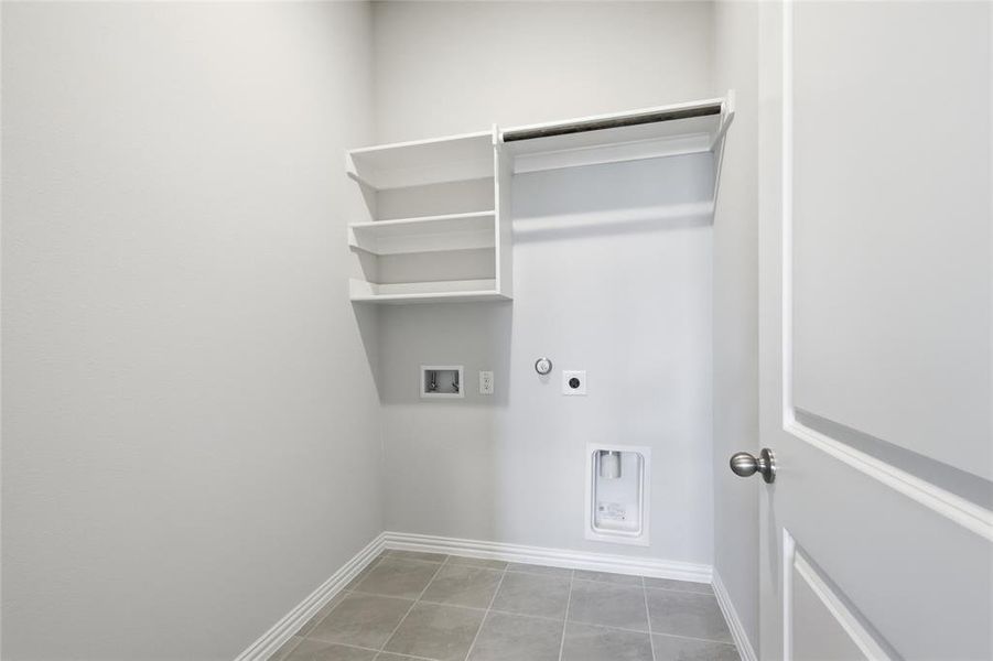 Laundry area featuring hookup for a gas dryer, hookup for an electric dryer, washer hookup, and light tile patterned flooring Laundry area featuring hookup for a gas dryer, hookup for an electric dryer, washer hookup, and light tile patterned flooring