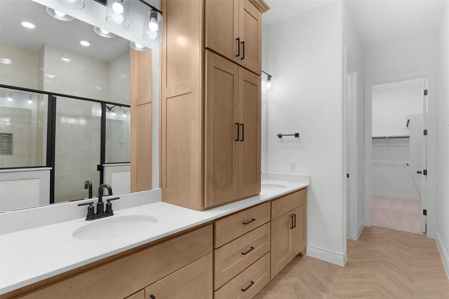 Bathroom featuring double vanity, a shower stall, a walk in closet, parquet floors, and recessed lighting