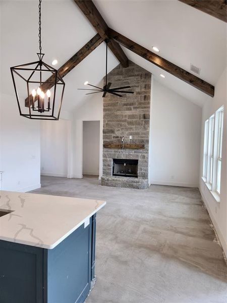 Living room with Stone Fireplace floor to Ceiling and stained beam and vaulted ceiling with stained beams