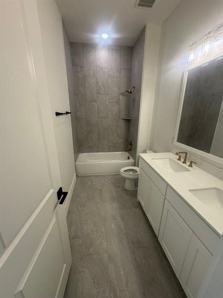 Modern bathroom featuring a double vanity with integrated sinks and bronze-tone fixtures
