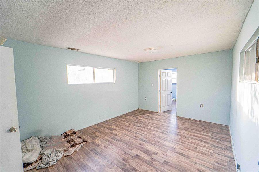 Empty room with wood finished floors and a textured ceiling Empty room with wood finished floors and a textured ceiling