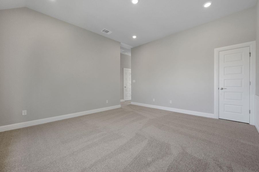 Empty room with light carpet, recessed lighting, and lofted ceiling