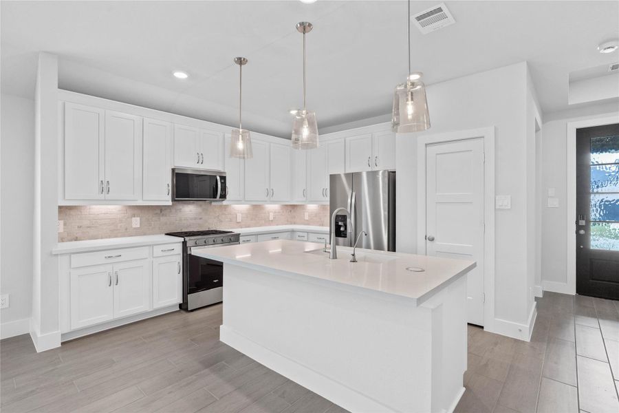 The extended quartz countertop creates a convenient breakfast bar, providing a casual and inviting space where stools can be added for quick meals or long conversations.