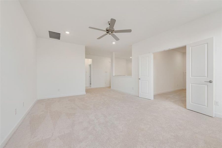 Unfurnished bedroom featuring ceiling fan and light carpet