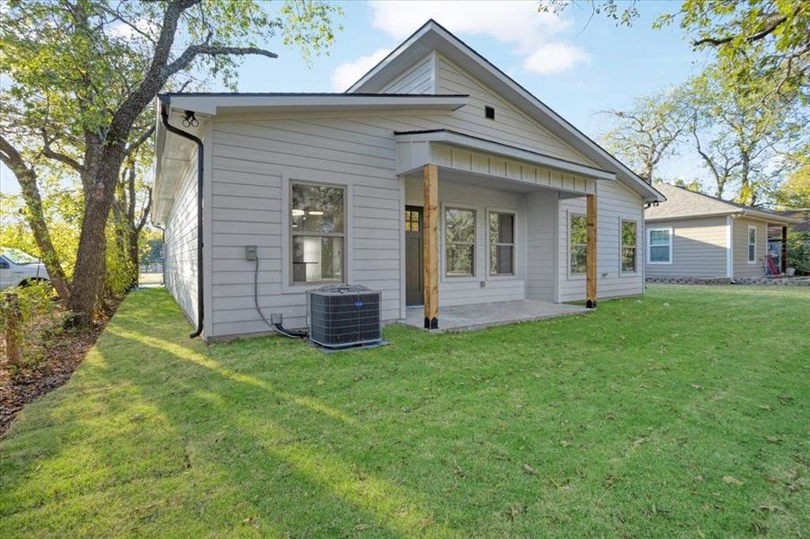 Rear view of house with a yard and cooling unit