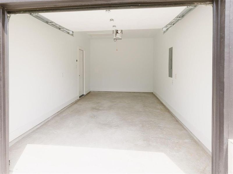 Garage featuring electric panel and a garage door opener Garage featuring electric panel and a garage door opener