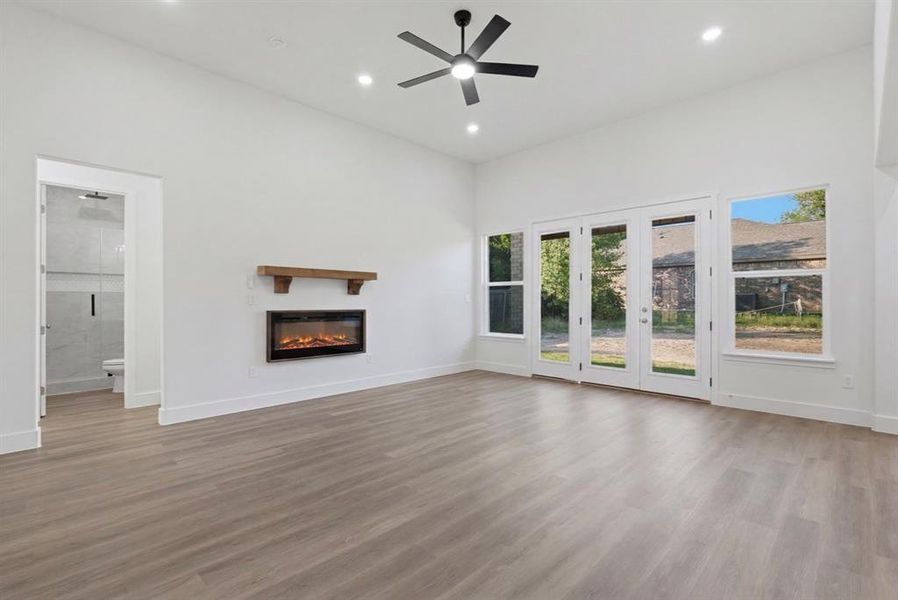 Spacious room featuring vaulted ceilings, recessed lighting, and wood-finish flooring