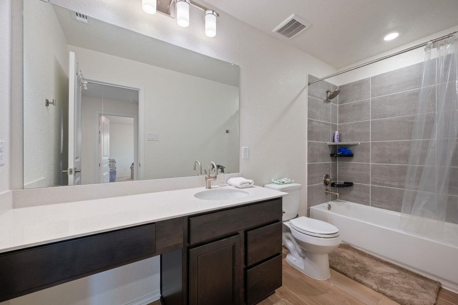 Bathroom featuring shower / bath combination with curtain, light wood finished floors, and vanity Bathroom featuring shower / bath combination with curtain, light wood finished floors, and vanity