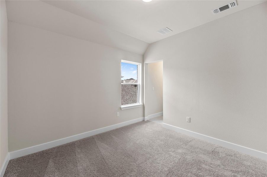 Empty room featuring carpet flooring and vaulted ceiling Empty room featuring carpet flooring and vaulted ceiling