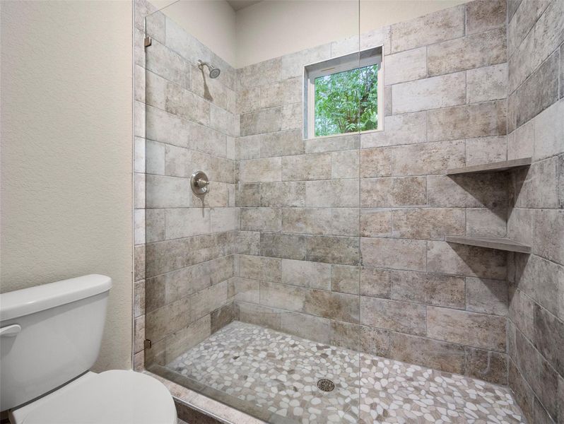 Full bathroom featuring a stall shower and a textured wall Full bathroom featuring a stall shower and a textured wall