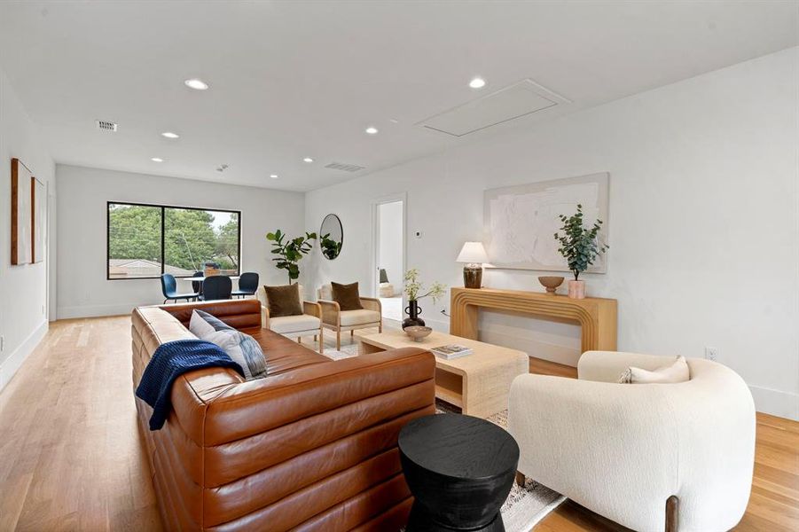 Living area featuring light wood-style flooring, recessed lighting, and attic access Living area featuring light wood-style flooring, recessed lighting, and attic access