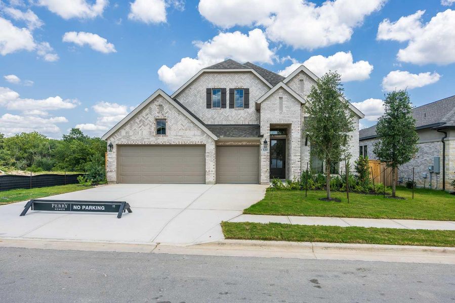 French country inspired facade with brick siding and driveway French country inspired facade with brick siding and driveway