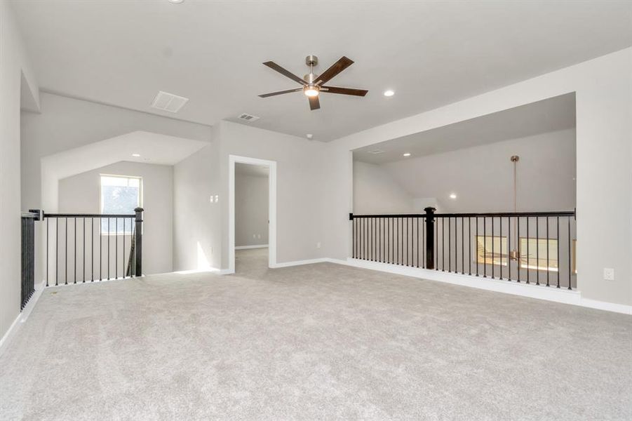 Elevate your leisure in this fantastic game room! Perfect for casual gatherings and adult gaming, it features plush carpet, high ceilings, custom paint, and numerous windows that welcome in ample natural light. Sample photo of completed home with similar floor plan. As-built interior colors and selections may vary.