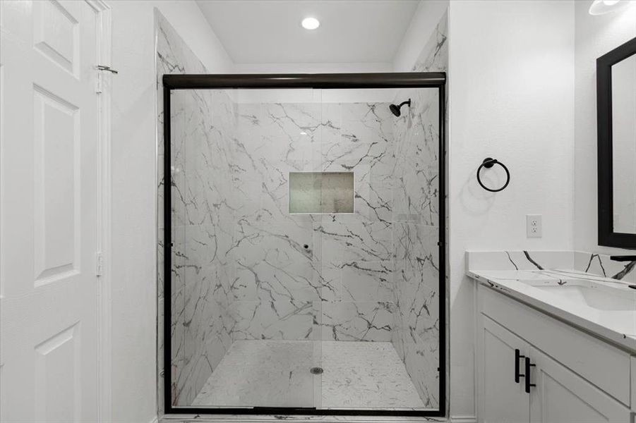 Full bathroom featuring vanity and a marble finish shower Full bathroom featuring vanity and a marble finish shower