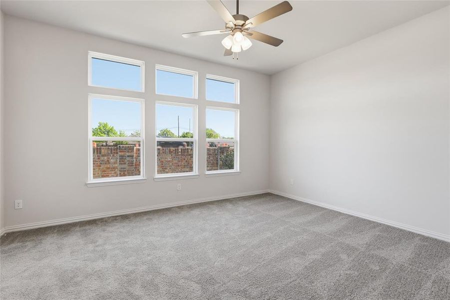 Empty room featuring light colored carpet and a ceiling fan Empty room featuring light colored carpet and a ceiling fan