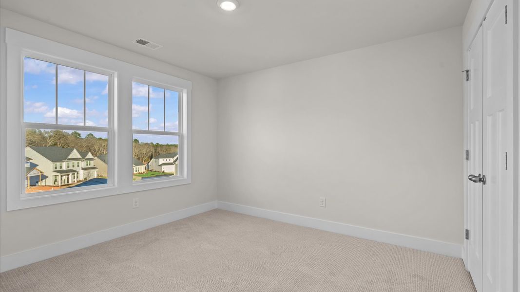 First-rate secondary bedroom with a spacious walk-in closet and elegant carpeted flooring