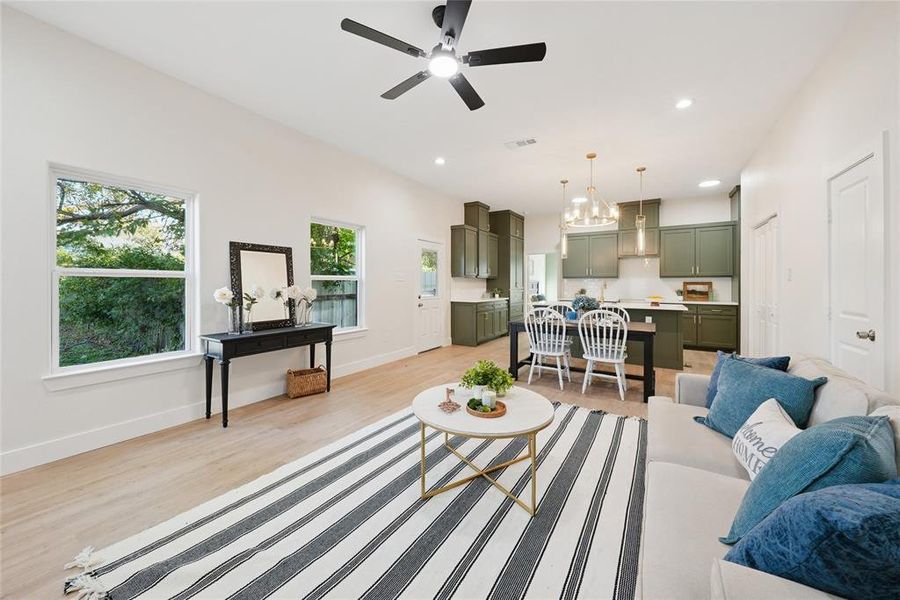 Living area featuring light wood-style flooring, recessed lighting, a chandelier, and ceiling fan Living area featuring light wood-style flooring, recessed lighting, a chandelier, and ceiling fan